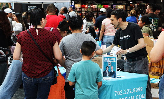 A De Castroverde team member connects with a family at the firm’s booth, sharing resources and materials during the festival.